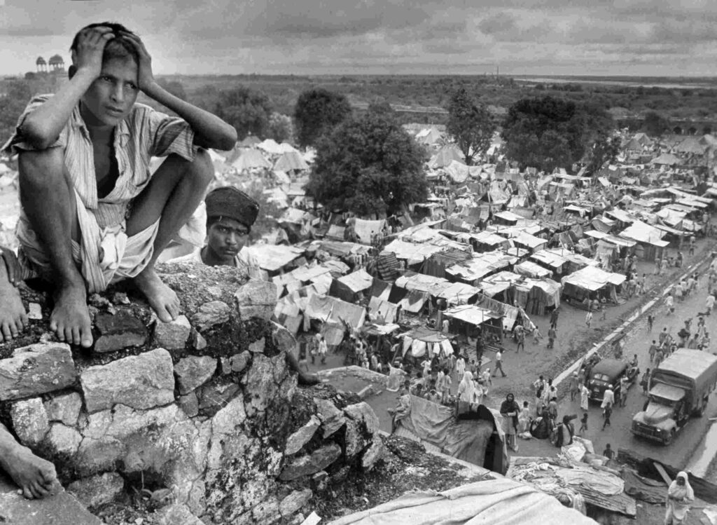 A distraught boy on the wall of a refugee camp in Delhi during Partition, in 1947